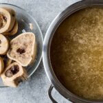 Homemade bone broth in a pot, rich and gelatinous after a long simmer
