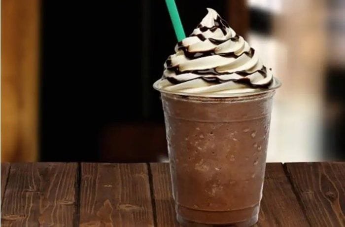Homemade blended iced coffee frappuccino topped with whipped cream and chocolate sauce