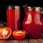 Glass of fresh homemade tomato juice with ice