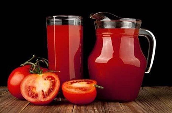 Glass of fresh homemade tomato juice with ice