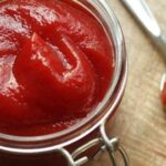 Homemade natural ketchup in a glass jar made from fresh tomatoes