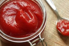 Homemade natural ketchup in a glass jar made from fresh tomatoes