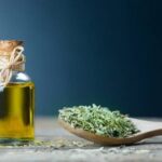 Homemade oregano infused olive oil in a glass bottle with dried oregano