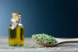 Homemade oregano infused olive oil in a glass bottle with dried oregano