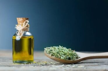 Homemade oregano infused olive oil in a glass bottle with dried oregano