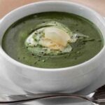 Homemade spinach soup with sour cream and Parmesan