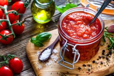 Homemade tomato sauce in a jar, made with peeled tomatoes, onion, and garlic