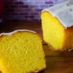 Glazed mandarin loaf cake sliced on a board