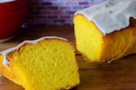 Glazed mandarin loaf cake sliced on a board