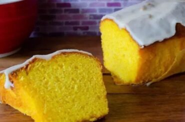 Glazed mandarin loaf cake sliced on a board