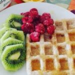 Oatmeal waffles served with fresh fruit and cream