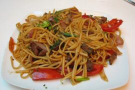 Peruvian beef tallarín saltado with red onion, tomato and scallions, homemade chifa noodle stir-fry