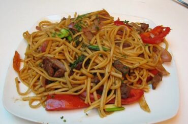 Peruvian beef tallarín saltado with red onion, tomato and scallions, homemade chifa noodle stir-fry