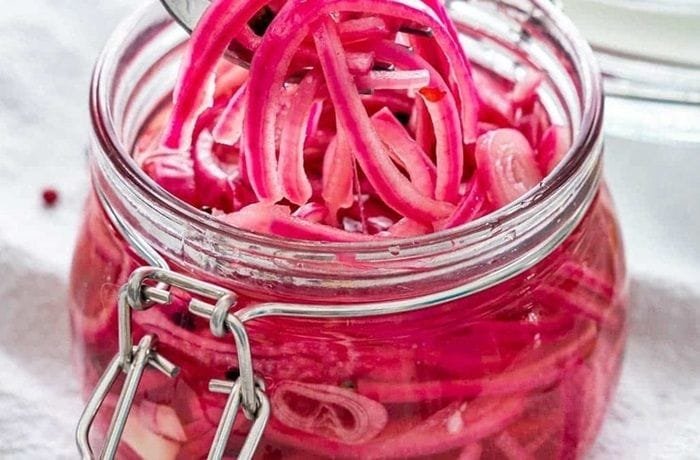 Jar of bright pink quick pickled red onions