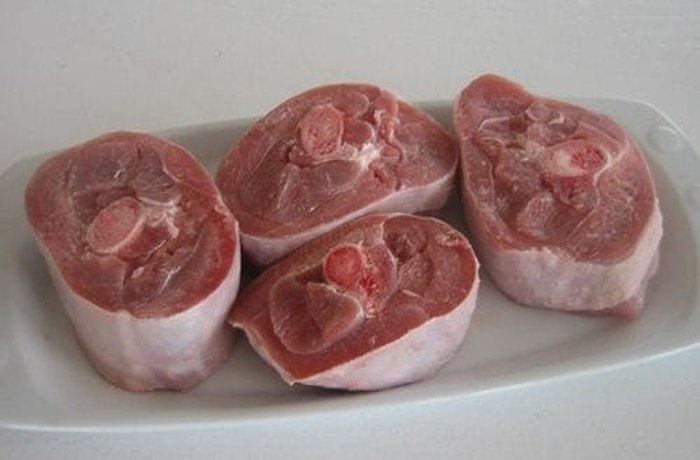 Raw turkey osso buco cuts on a baking tray