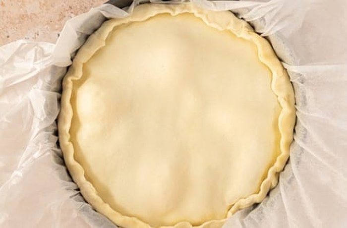 Chicken pascualina sealed with its top dough layers before baking