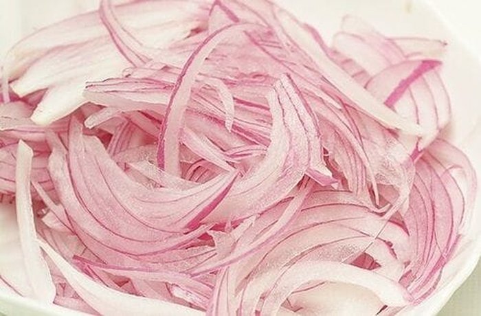 Red onion sliced lengthwise for Peruvian tallarín saltado