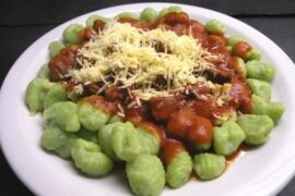 Green spinach gnocchi with tomato sauce and grated parmesan