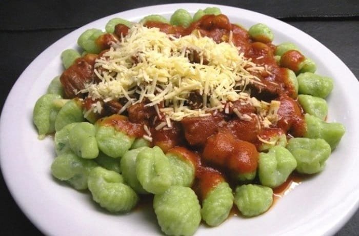 Green spinach gnocchi with tomato sauce and grated parmesan