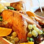 Roast stuffed Christmas turkey decorated with grapes, oranges, and apples
