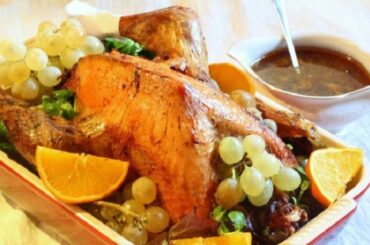Roast stuffed Christmas turkey decorated with grapes, oranges, and apples