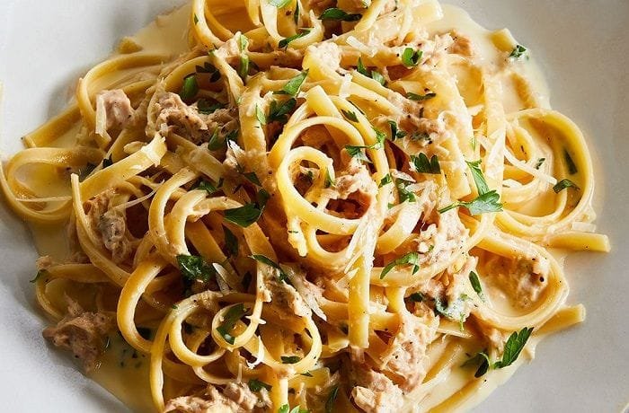 Tagliatelle with tuna and cream sauce garnished with parsley and chives